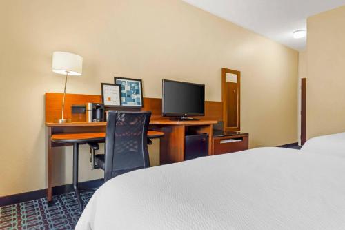 a hotel room with a bed and a desk with a computer at Comfort Inn & Suites Green Bay Stadium Area in Green Bay