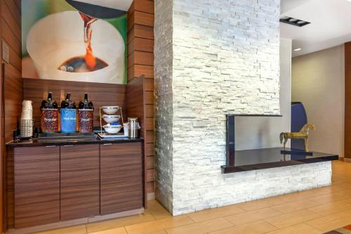 a bar in a room with a stone wall at Comfort Inn & Suites Green Bay Stadium Area in Green Bay