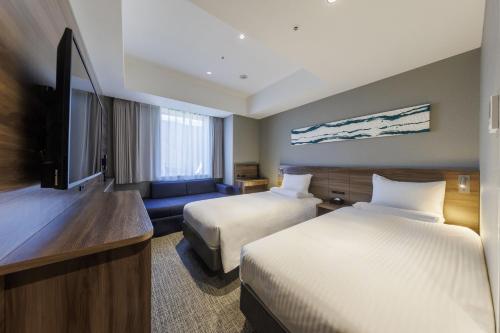 a hotel room with two beds and a flat screen tv at Far East Village Hotel Tokyo Ariake in Tokyo