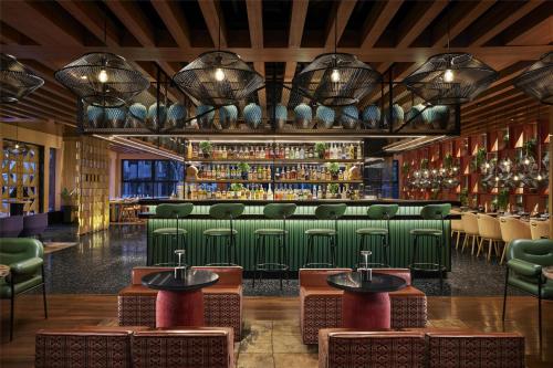 a bar with green chairs and a green bar at Hyatt Centric Sector17 Chandigarh in Chandīgarh