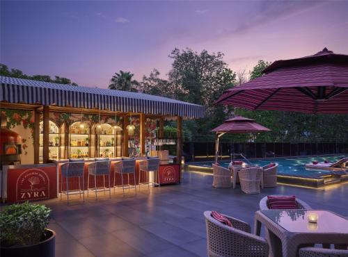 a restaurant with tables and chairs and a swimming pool at Hyatt Centric Sector17 Chandigarh in Chandīgarh