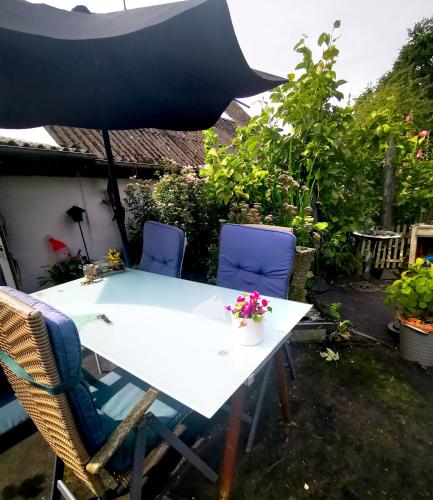 a white table with chairs and an umbrella at Den gamle smedie in Holbæk