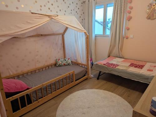 a bedroom with two bunk beds and a window at Villa moderne, piscine & plage in Lattes