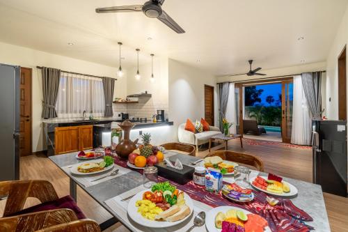 een keuken en woonkamer met een tafel vol eten bij Villa Alam Bayu in Amed