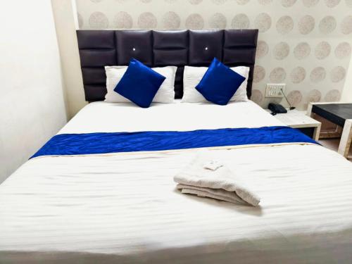 a bed with blue and white sheets and blue pillows at Hotel Sunway in Ahmedabad