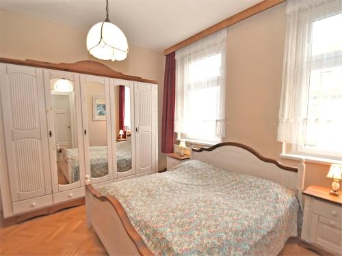 a bedroom with a bed and a mirror at Gruppenhaus mit Sauna bis zu 18 Personen in Treuen