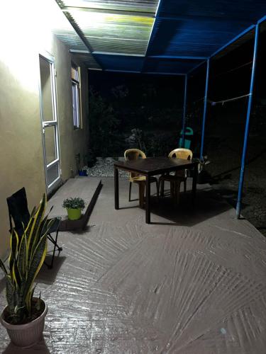a patio with a table and two chairs under a blue tent at Chez sanny in Mt Bois Noir