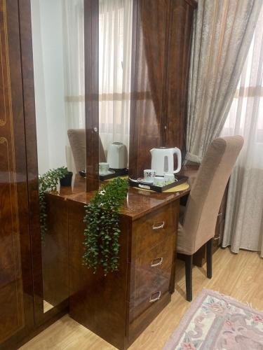 an office with a wooden desk with a plant on it at Riian Luxury Apartments in Ulcinj