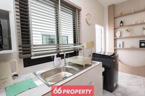 eine Küche mit Spüle und Fenster in der Unterkunft Minimalist Modern Home, Smart TV, Kitchen in Chiang Mai