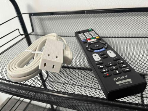 a sony remote control and a charger on a shelf at KT2 ブロッサムガーデン103号室Blossom Garden103 in Takahate