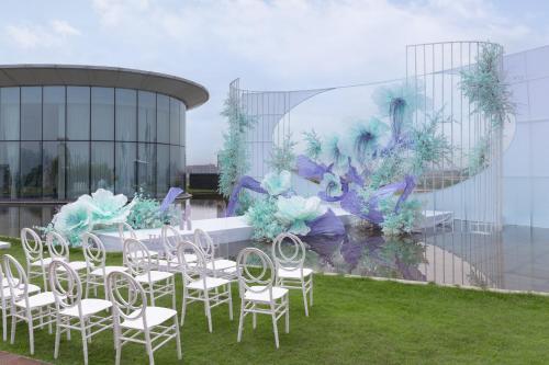 a group of chairs and tables in front of a building at Vignette Collection The Xanadu Guangzhou, an IHG Hotel in Guangzhou