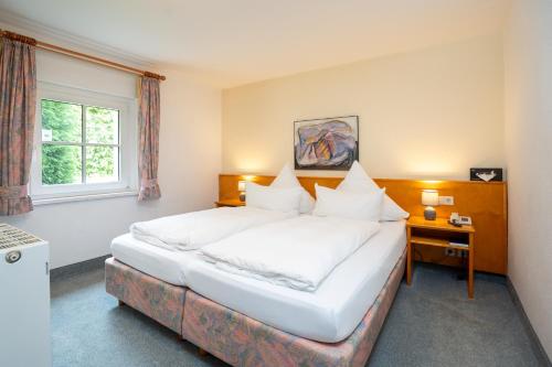 a bedroom with a large white bed and a window at Hotel Sonne in Seiffen