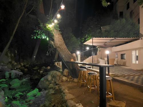 a table and chairs next to a tree at night at Casa Riviera in Zahlé