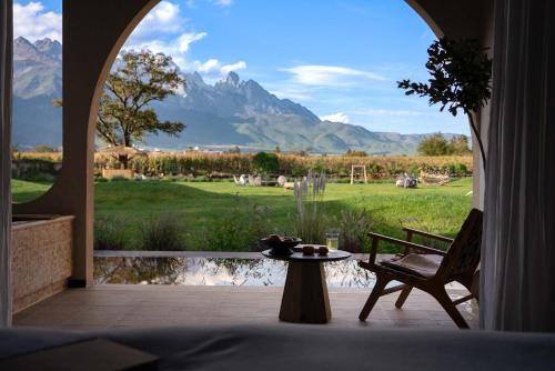 a room with a table and a view of a mountain at Snow Mountain in Baisha