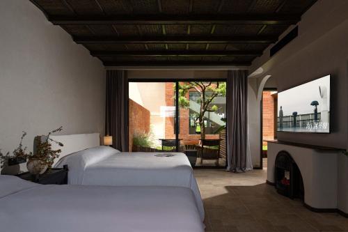 a bedroom with two beds and a fireplace and a window at Snow Mountain in Baisha