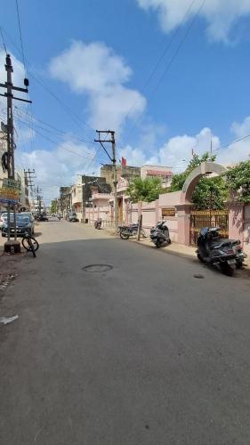 an empty street with cars parked on the side of the road at The Imperial Regency in Porbandar