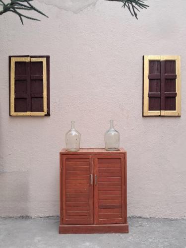 two vases on top of a wooden cabinet next to a wall at The Imperial Regency in Porbandar