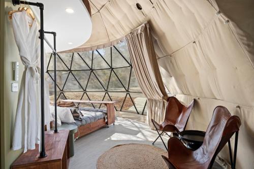 a room with a bed and chairs in a tent at BIG4 Yarra Valley Park Lane Holiday Park in Healesville
