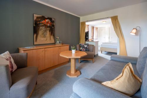 a living room with two couches and a table at Hotel Sonne in Seiffen
