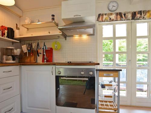 a kitchen with white cabinets and an oven at 6 person holiday home in SÖLVESBORG in Björkenäs