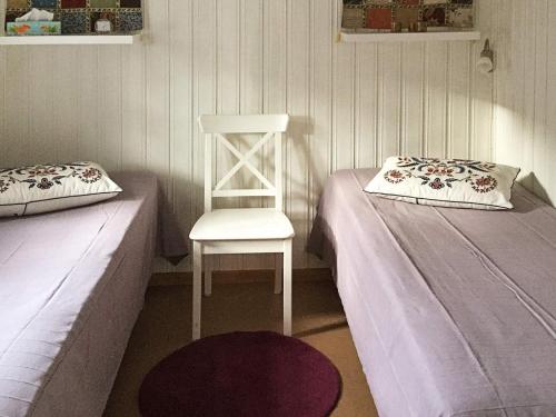 a room with two beds and a white chair at 6 person holiday home in SÖLVESBORG in Björkenäs