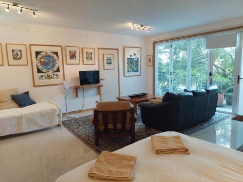 a living room with a couch and a tv at The Gallery Beach Apartment in Kiama