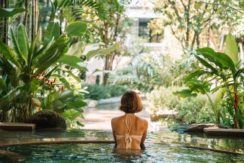 a woman in a bikini sitting in a swimming pool at The Park Nine Hotel Srinakarin in Bangkok