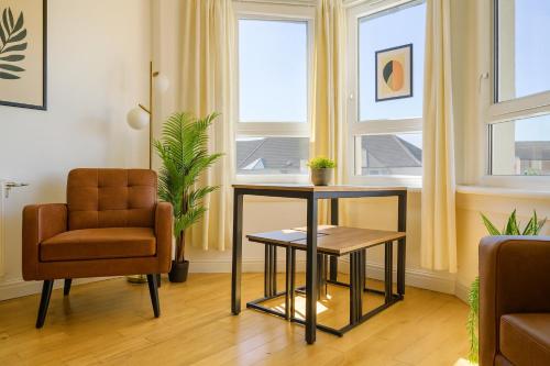 een woonkamer met een stoel en een tafel bij Walk to Hydro and SEC Modern 3BR Free Parking in Glasgow
