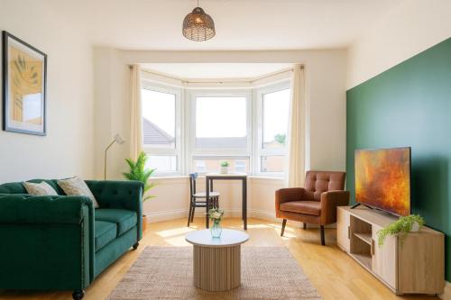 a living room with a green couch and a chair at Walk to Hydro and SEC Modern 3BR Free Parking in Glasgow