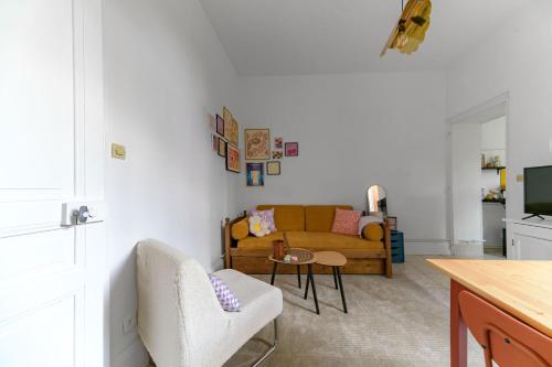 a living room with a couch and a table at Le Beaulieu - Appartement lumineux, stationnement gratuit in Vichy