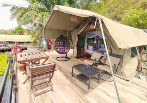 a tent on a wooden deck with chairs and a table at Wag Hill Lodge & Spa in Mwanza