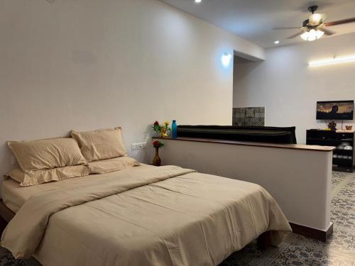a bedroom with a bed and a ceiling fan at Phalguni Farm Stay in Nanjangūd