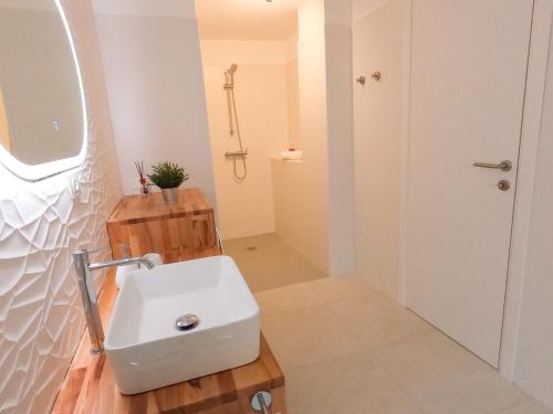 a bathroom with a white sink and a mirror at Luxi Apartment Teulada in Teulada