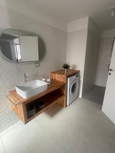 a bathroom with a sink and a washing machine at Luxi Apartment Teulada in Teulada
