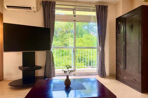 a living room with a table and a large window at FujiteraCanvas201 in Gotemba