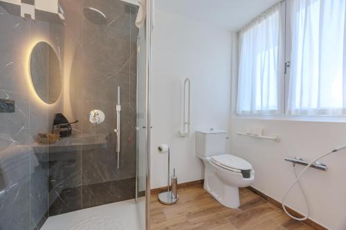 a bathroom with a toilet and a glass shower at Hotel San Marco in Bardolino