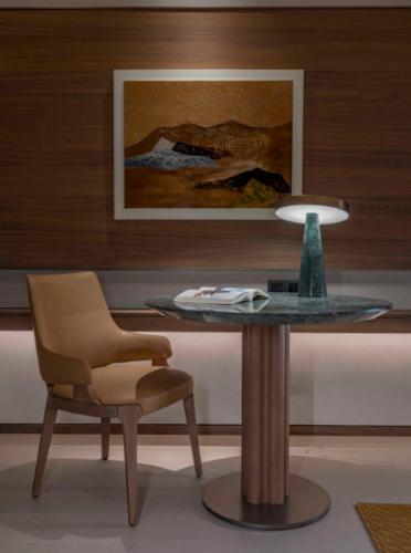 a table with a chair and a lamp in a room at PERNULO Hotel Fuzhou in Fuzhou