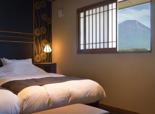 a bedroom with a bed with a view of a mountain at 八海 木花館 in Oshino