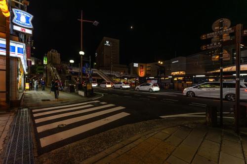 a busy city street at night with cars parked at おやど紀伊国屋大黒町通 in Nagasaki