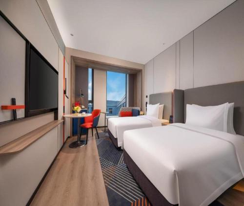 a hotel room with two beds and a flat screen tv at Hotel CORAL COVEE Near Delhi Airport BY GROSS GROUP in New Delhi