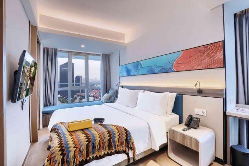 a hotel room with a large bed and a tv at Citadines Antasari Jakarta in Jakarta