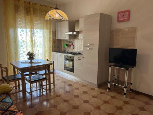 a kitchen with a table and a dining room at Holiday residence Sole San Marco in Calatabiano