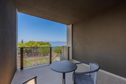 a balcony with a table and chairs and a large window at Hotel San Marco in Bardolino