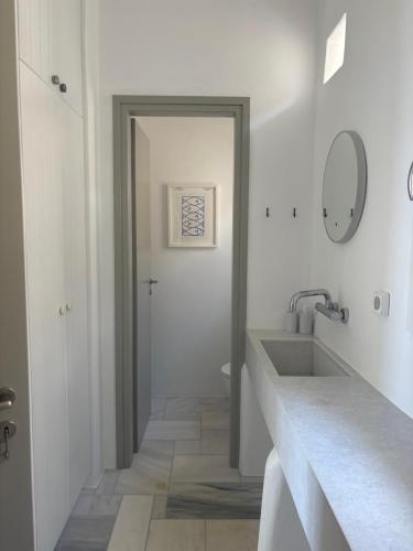 バトシにあるAVRA, a serene Cycladic villa with private pool overlooking the Aegean Seaの洗面台と鏡のある白いバスルーム