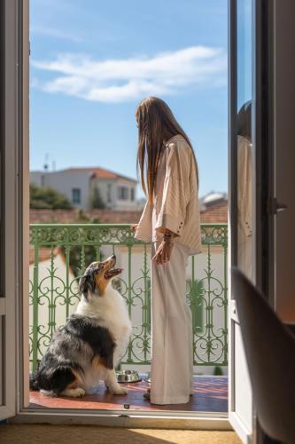 a woman yelling at a dog on a porch at Hotel Verlaine in Cannes