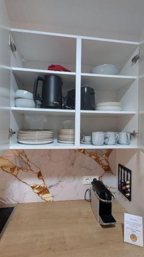 a kitchen shelf with plates and dishes on it at Luxuriöses Apartment mit Balkon - Fountain Suite Balcony in Gmunden