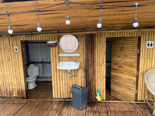 a bathroom with a toilet and a sink at บ้านไม่ไผ่บ้านเวร-BambooHouse Banwen in Ban Khun Nam Nan