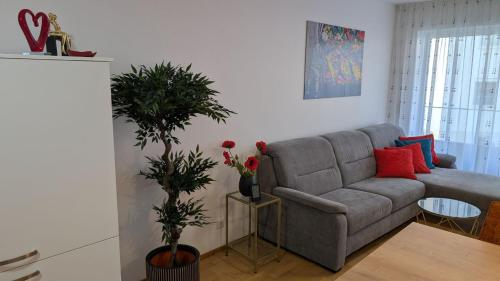 a living room with a couch and a potted plant at Luxuriöses Apartment mit Balkon - Fountain Suite Balcony in Gmunden