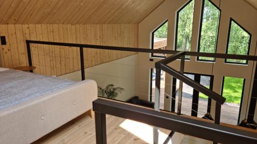 a bedroom with a bed and a staircase with windows at Aura Будинки для відпочинку in Aleksandriya
