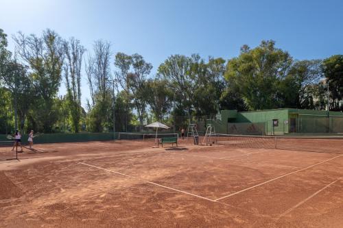 a tennis court with two people standing on it at Kimpton Los Monteros Marbella by IHG in Marbella